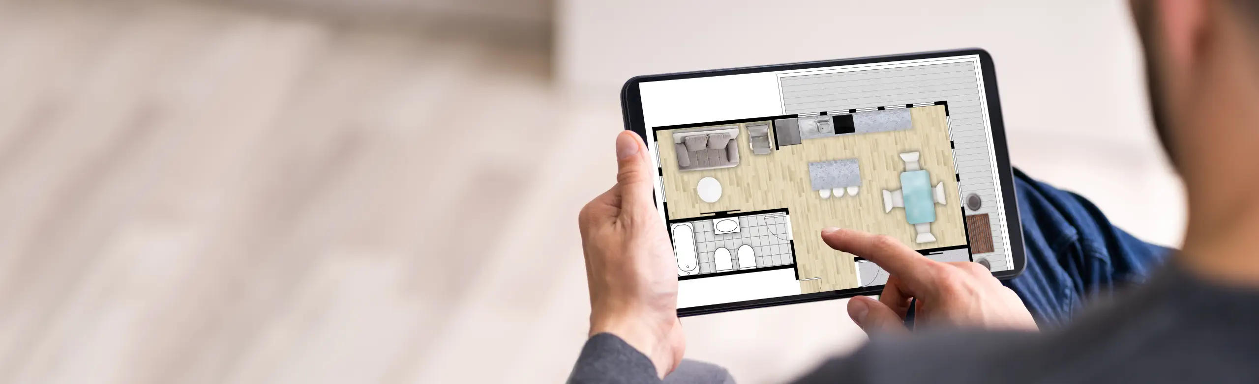 Immobilienmakler zeigt Grundriss einer Immobilie auf einem Tablet